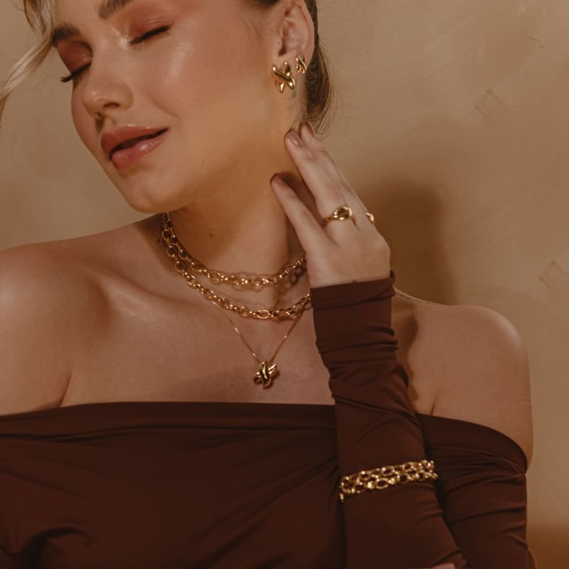 BRINCO DESIGN X PEQUENO BANHADO A OURO 18K