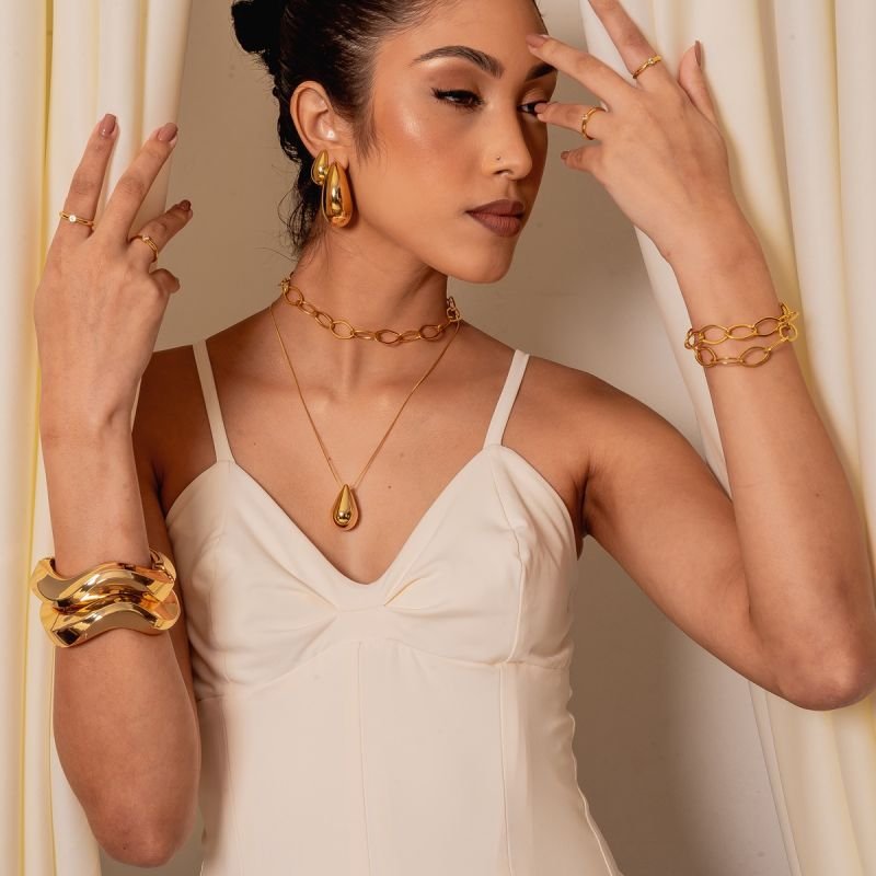 BRINCO GOTA ABAULADA 29X41MM ABS DOURADO FOLHEADO