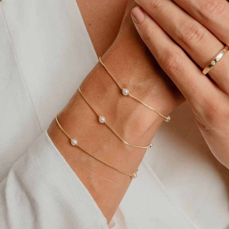 PULSEIRA TRÊS MINI PÉROLAS AFASTADAS BANHADO A OURO 18K